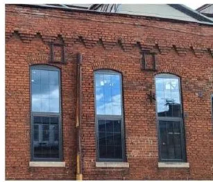 Wood-clad windows set into a brick facade